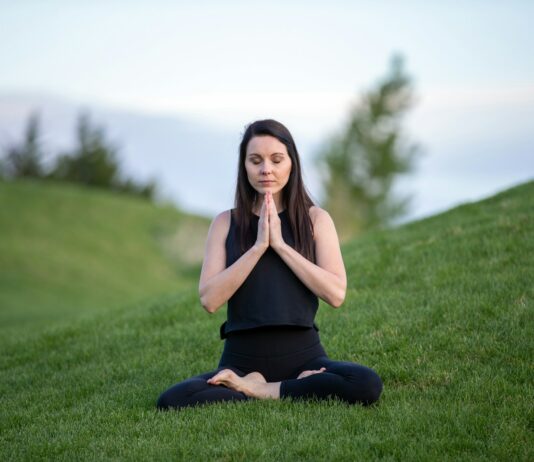요가와 명상으로 몸과 마음 치유하기 woman in black tank top and black pants sitting on green grass field during daytime