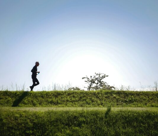 조깅의 정신 건강 효과 man in black jacket and pants running on green grass field during daytime