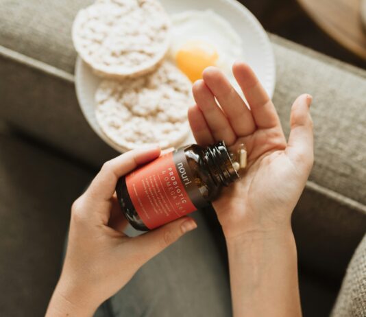 프로바이오틱스가 면역력에 미치는 과학적 증거 person holding red bottle