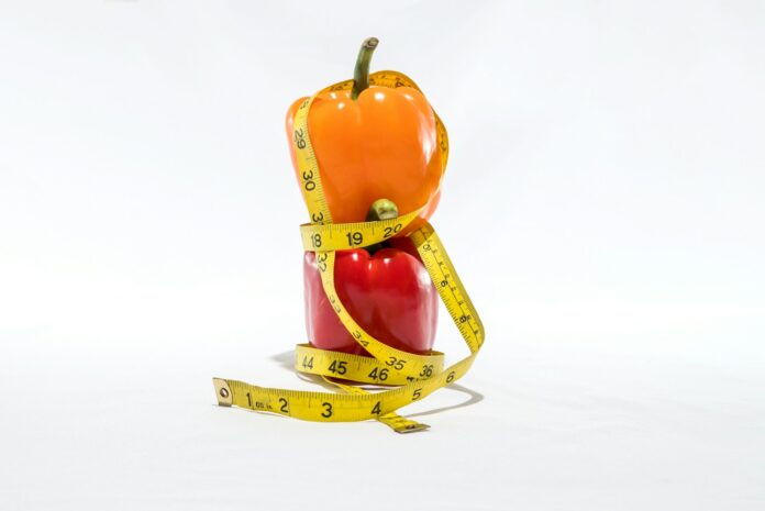Photo by Omar Encarnacion a measuring tape wrapped around a bell pepper