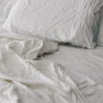 “수면부터 달라진다”…새롭게 떠오르는 ‘슬리핑 루틴’ 실천 열풍 A rumpled white duvet and pillows on a bed.